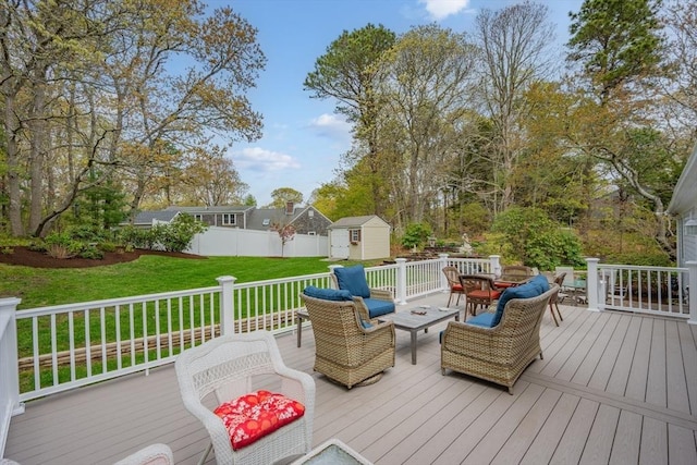 deck with outdoor dining space, a storage shed, and an outbuilding