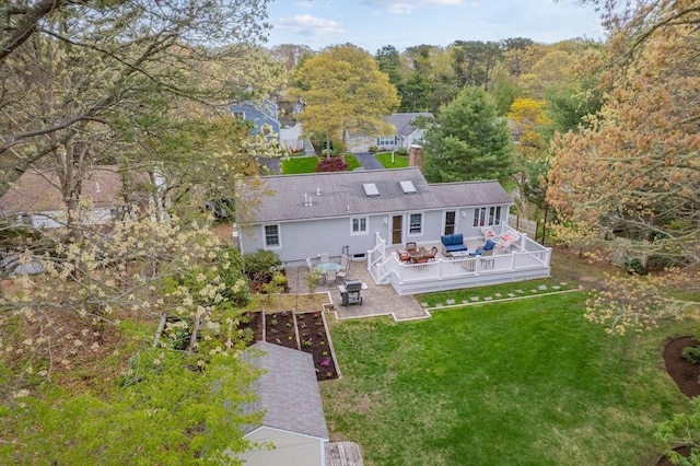 back of house featuring a deck, a lawn, outdoor lounge area, a chimney, and a patio area