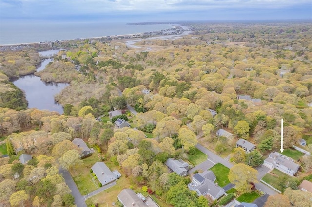 aerial view of property and surrounding area featuring a large body of water and a forest