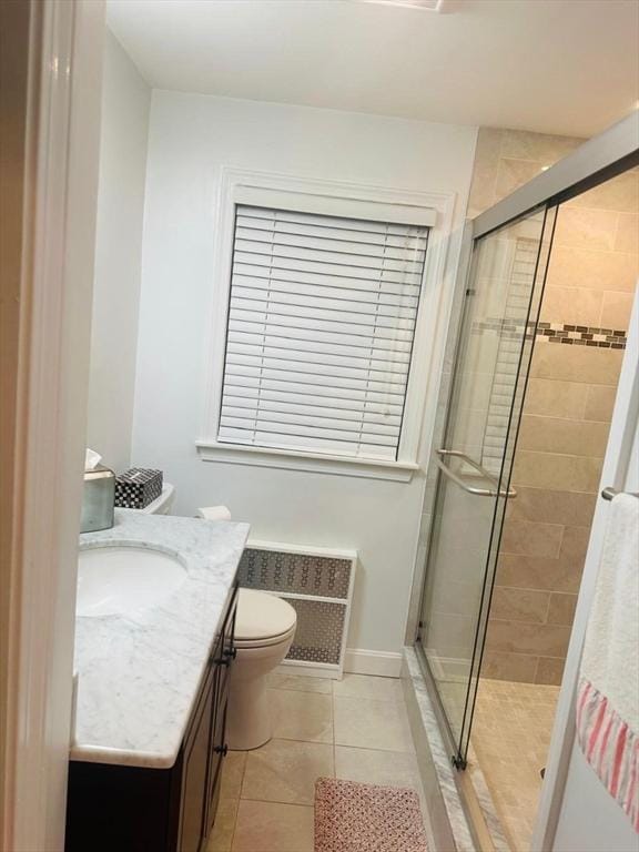 bathroom featuring tile patterned flooring, vanity, toilet, and walk in shower