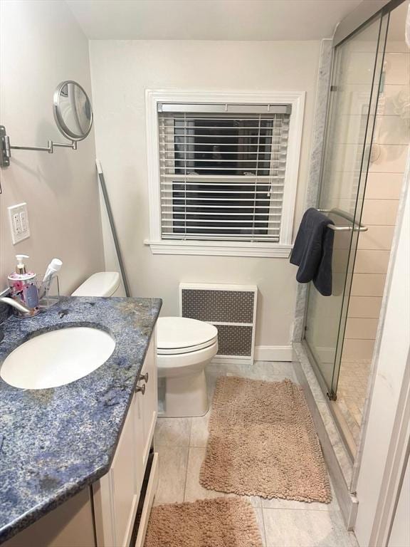 bathroom featuring vanity, radiator, tile patterned flooring, toilet, and an enclosed shower