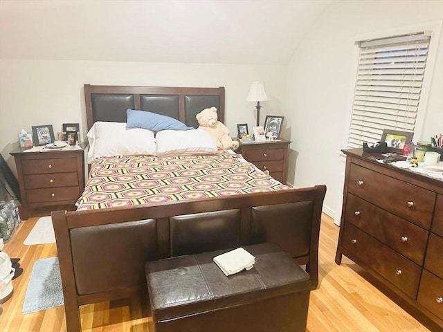 bedroom featuring light hardwood / wood-style floors and vaulted ceiling