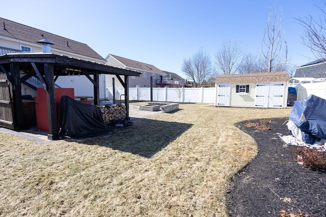 view of yard featuring an outbuilding, a garden, a fenced backyard, a gazebo, and a storage unit