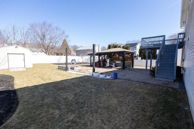 view of yard with a patio, stairway, a fenced backyard, a gazebo, and an outdoor structure