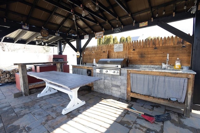 view of patio / terrace featuring a gazebo, grilling area, an outdoor kitchen, and fence