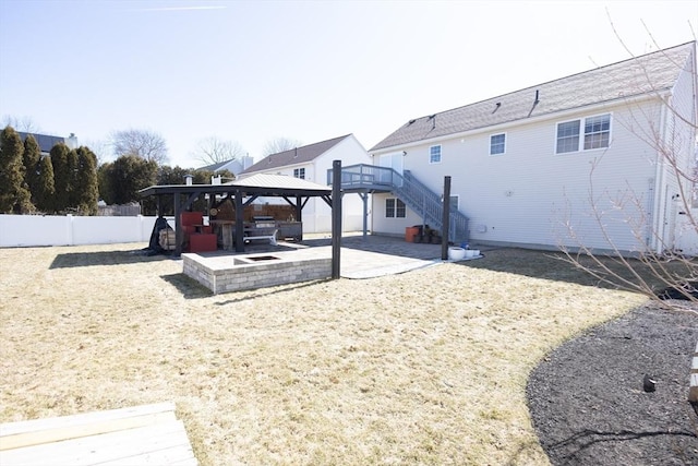 rear view of house featuring stairs, a gazebo, a fenced backyard, a yard, and a patio