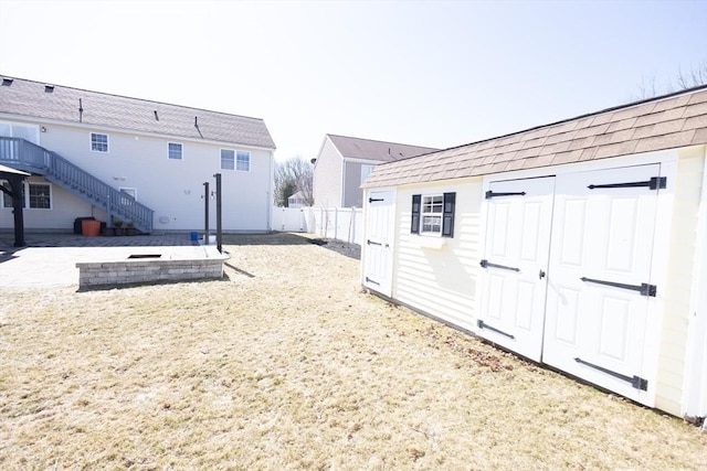 view of yard featuring stairs, an outbuilding, fence, and a shed