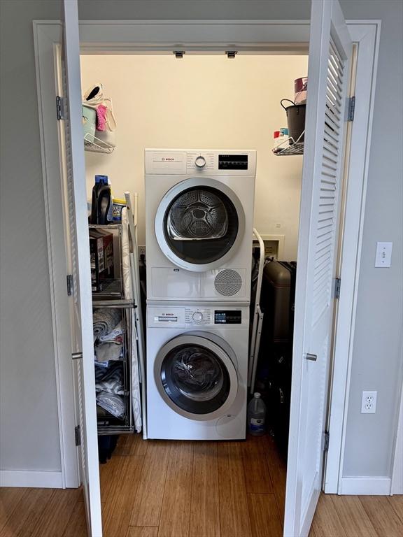 16 Miner St Unit 307, Boston, MA 02215 - laundry area with stacked washer / drying machine and wood finished floors