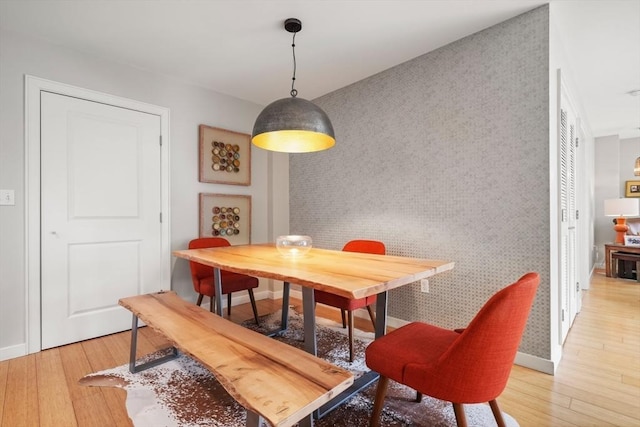 16 Miner St Unit 307, Boston, MA 02215 - dining space featuring an accent wall, light wood-type flooring, wallpapered walls, and baseboards