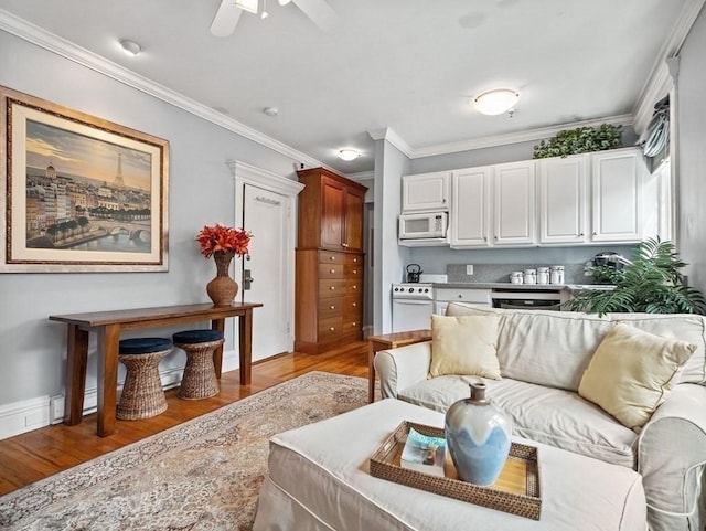 living room featuring ceiling fan, ornamental molding, and light hardwood / wood-style flooring