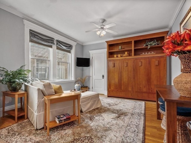 interior space with light wood-type flooring, ceiling fan, and ornamental molding