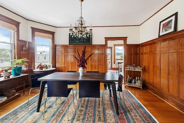 dining area with ornamental molding, an inviting chandelier, and dark hardwood / wood-style flooring