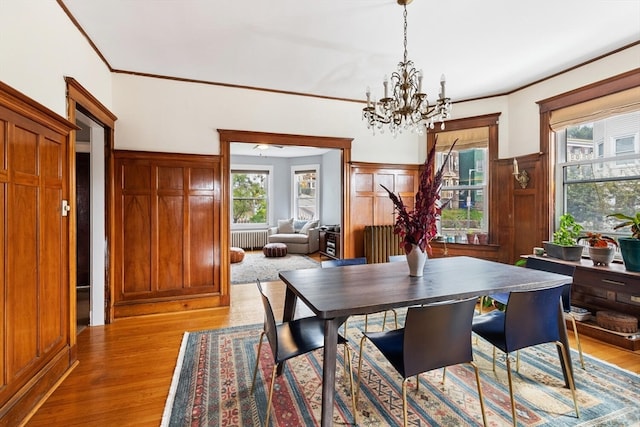 dining space with light wood-type flooring, a chandelier, and a wealth of natural light