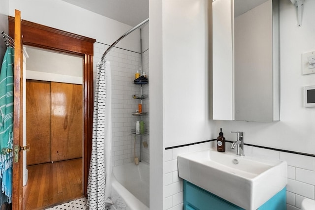 bathroom with shower / tub combo, vanity, and tile walls