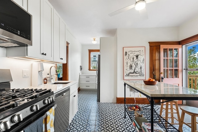 kitchen featuring black appliances, sink, ceiling fan, and white cabinets