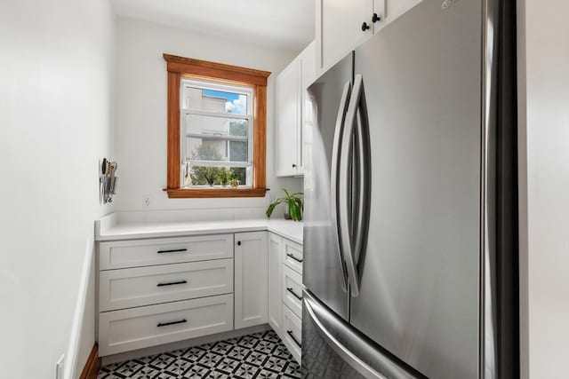 kitchen featuring stainless steel refrigerator and white cabinets