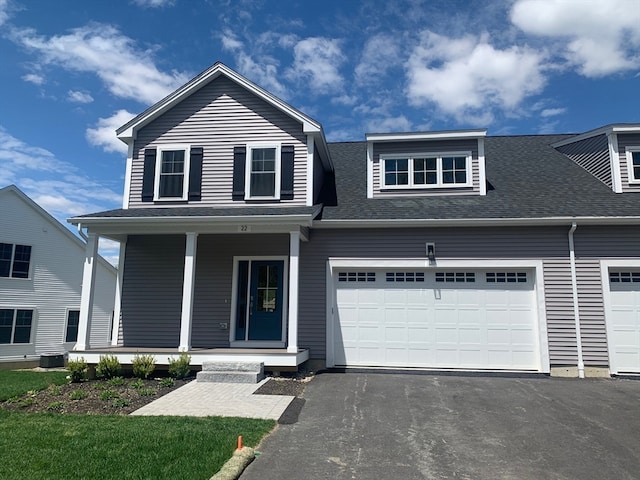 view of front facade with a garage, a porch, and central AC unit