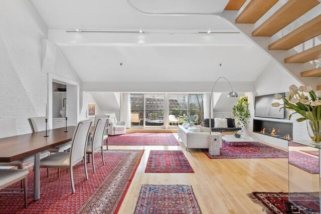 living room with high vaulted ceiling and light hardwood / wood-style flooring