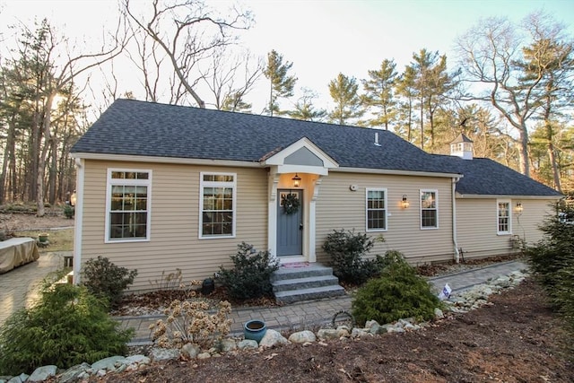 view of front of home with a chimney and a shingled roof