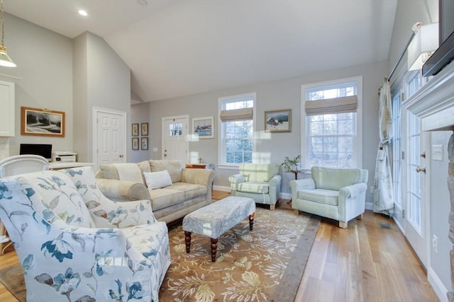 living room featuring high vaulted ceiling, wood finished floors, recessed lighting, a fireplace, and baseboards