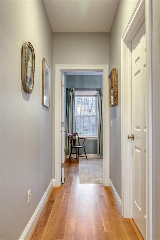 hallway featuring baseboards and light wood finished floors