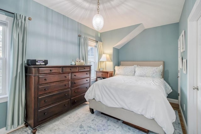 bedroom featuring lofted ceiling and baseboards