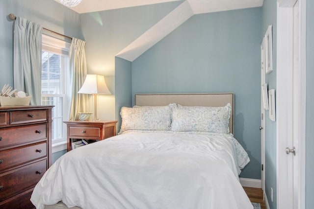 bedroom featuring baseboards and vaulted ceiling