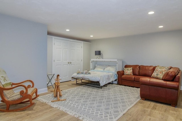 bedroom with recessed lighting, wood finished floors, a closet, and baseboards