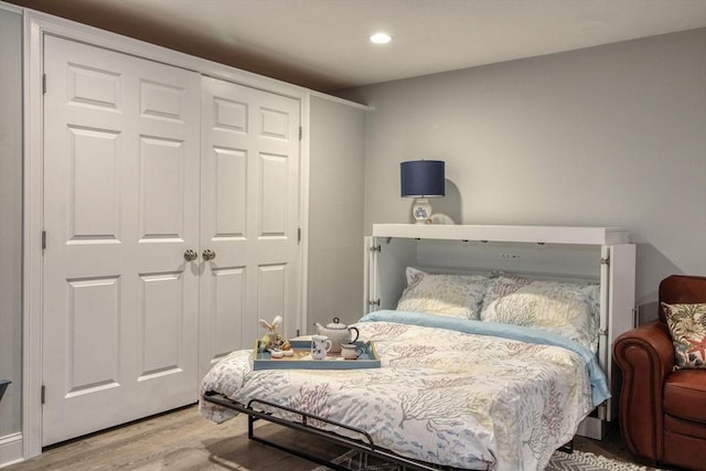 bedroom with a closet, recessed lighting, and wood finished floors