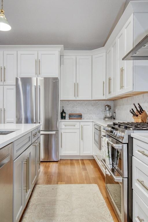 kitchen featuring stainless steel appliances, white cabinetry, light wood-style floors, and light countertops