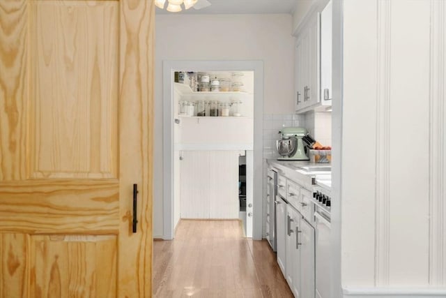 127 Highland Ave, Watertown, MA 02472 - kitchen with light countertops, light wood-style floors, tasteful backsplash, and white cabinetry