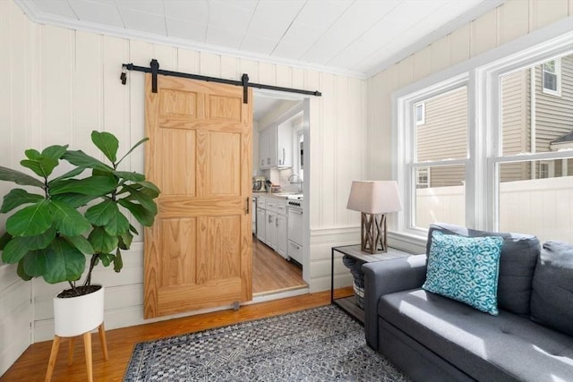 127 Highland Ave, Watertown, MA 02472 - living area featuring a barn door, light wood finished floors, and crown molding
