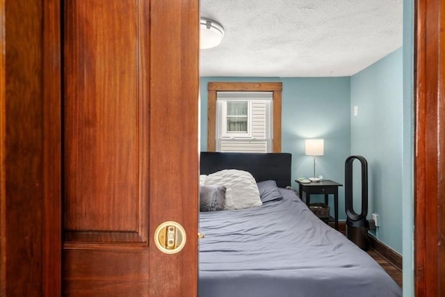 127 Highland Ave, Watertown, MA 02472 - bedroom featuring baseboards, a textured ceiling, and wood finished floors