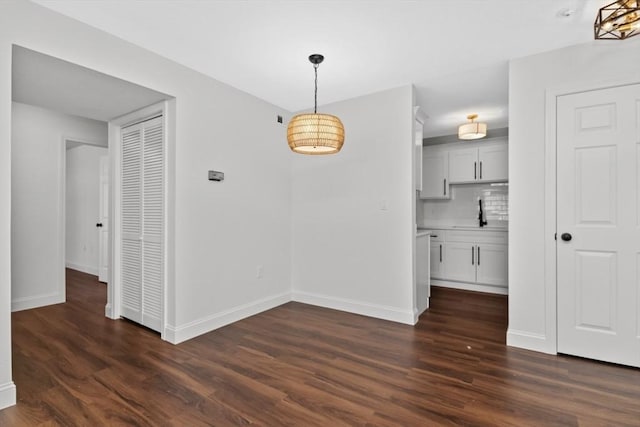 unfurnished dining area with sink and dark wood-type flooring