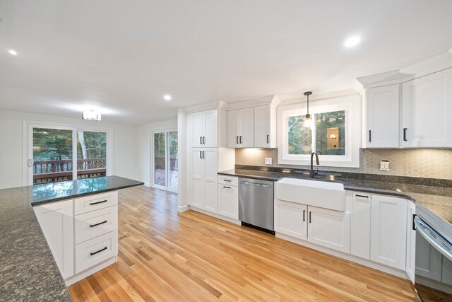 kitchen featuring dishwasher, white cabinets, light hardwood / wood-style flooring, and sink