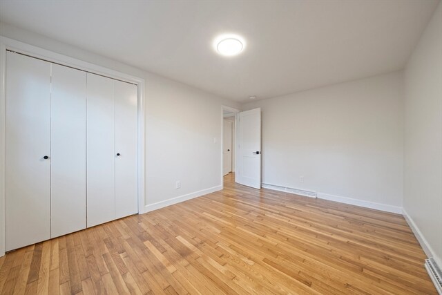 unfurnished bedroom featuring light wood-type flooring and a closet