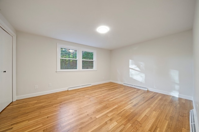 unfurnished bedroom with light wood-type flooring and a baseboard radiator