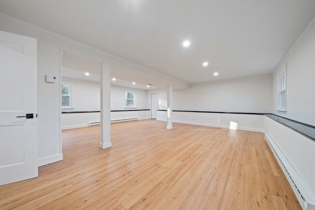 interior space with ornamental molding, a baseboard radiator, and light wood-type flooring