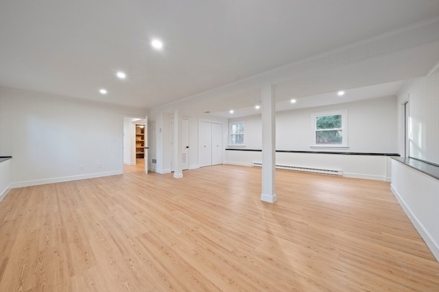 basement with baseboard heating and light wood-type flooring