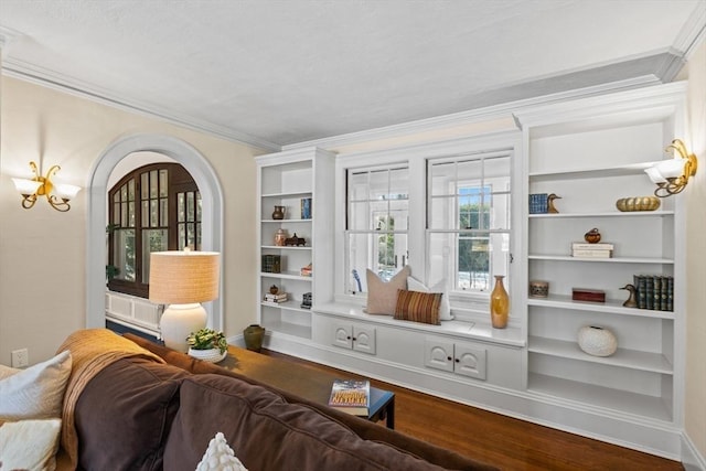 living area featuring crown molding, wood-type flooring, built in shelves, and a notable chandelier