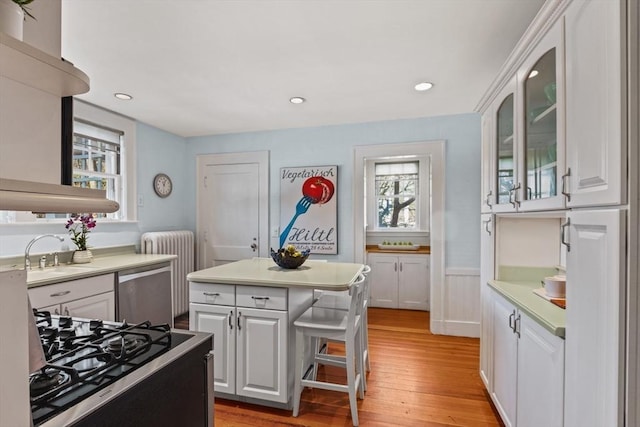 kitchen with dishwasher, sink, white cabinets, a center island, and gas range oven