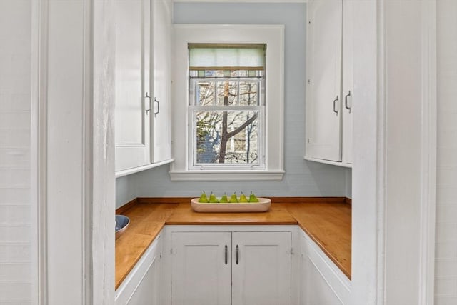 kitchen featuring white cabinetry and butcher block countertops