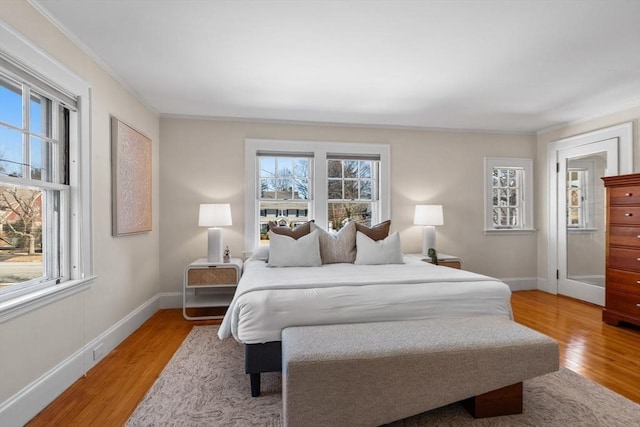 bedroom with ornamental molding and light wood-type flooring