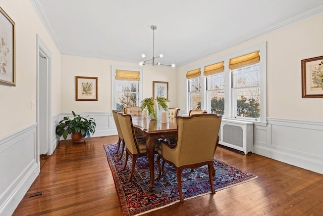 dining room with ornamental molding, a healthy amount of sunlight, radiator, and dark hardwood / wood-style flooring