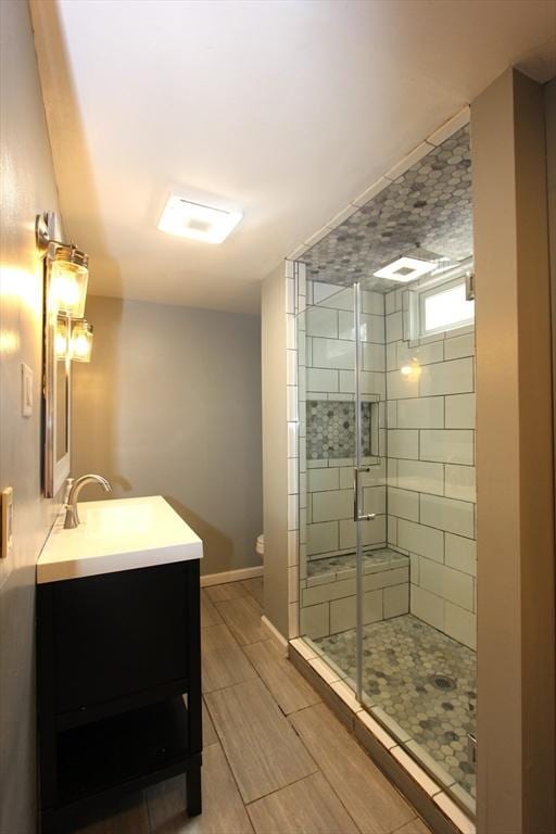 271 Gibson St, Lowell, MA 01851 - full bathroom with a stall shower, vanity, toilet, and wood tiled floors