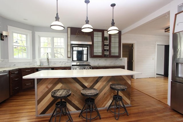 271 Gibson St, Lowell, MA 01851 - kitchen featuring range, wall chimney range hood, a breakfast bar, a sink, and light countertops