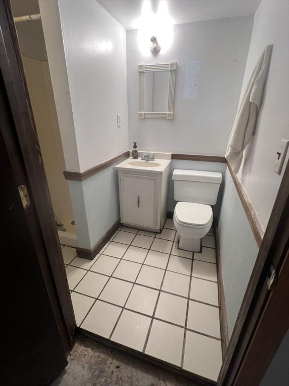 271 Gibson St, Lowell, MA 01851 - bathroom with toilet, vanity, a shower, and tile patterned floors