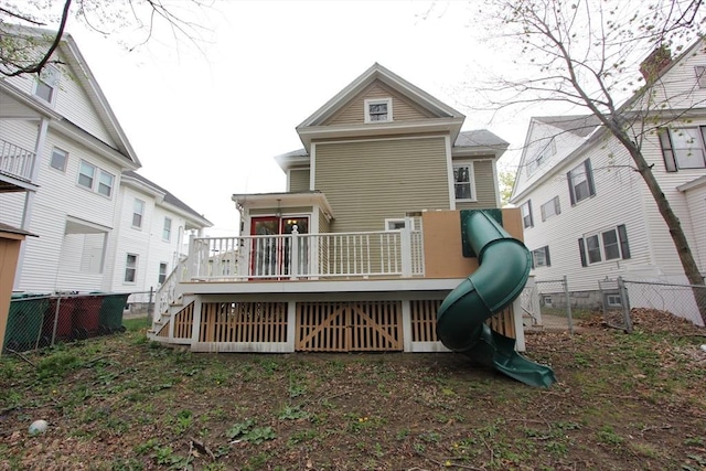 271 Gibson St, Lowell, MA 01851 - back of property featuring fence, a wooden deck, and a playground