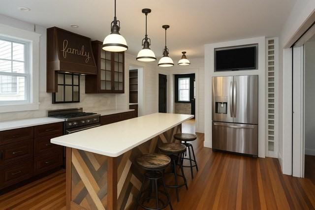 271 Gibson St, Lowell, MA 01851 - kitchen with stainless steel fridge, dark wood-style floors, glass insert cabinets, black gas stove, and healthy amount of natural light