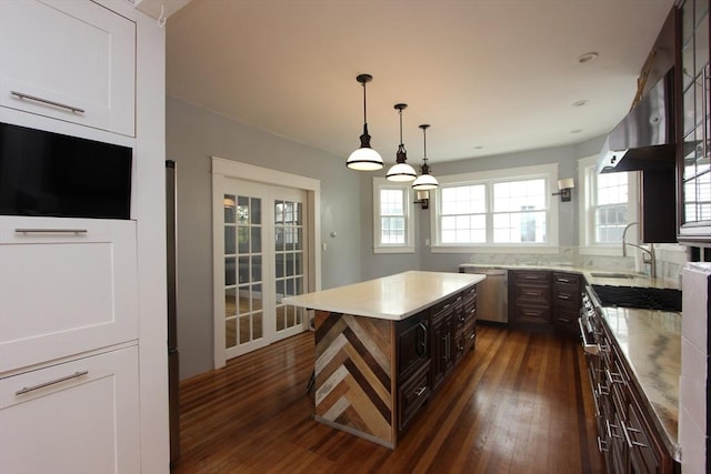 271 Gibson St, Lowell, MA 01851 - kitchen featuring a sink, dark wood finished floors, stainless steel dishwasher, dark brown cabinets, and hanging light fixtures
